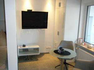 ein Wohnzimmer mit einem Flachbild-TV an der Wand in der Unterkunft Wiethegers Ferienwohnungen Gästehaus Centrum II in Willingen