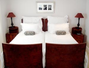 2 camas en un dormitorio con 2 mesitas de noche en Aloe Cottage, en Darling