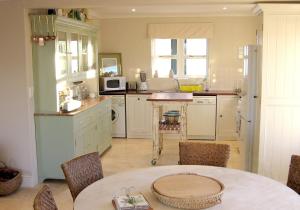 cocina con mesa y sillas en una habitación en Aloe Cottage, en Darling