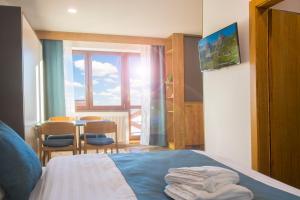 a bedroom with a bed and a table and a window at Penzión Darinka in Poprad