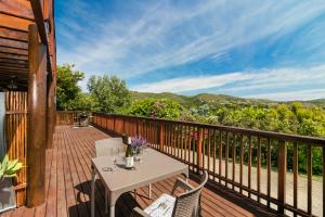 a patio with a table and chairs on a deck at Stellata - inverter for guests' comfort in Knysna
