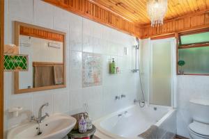 a bathroom with a tub and a sink and a toilet at Stellata - inverter for guests' comfort in Knysna