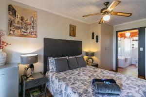 a bedroom with a bed and a ceiling fan at Stellata - inverter for guests' comfort in Knysna