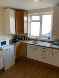 a kitchen with a sink and a microwave at Sutton Park Lodge in Sutton Coldfield