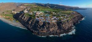 an island in the ocean with houses on a cliff at Hotel Jardín Tecina in Playa de Santiago