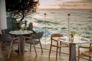 dwa stoły i krzesła z widokiem na ocean w obiekcie Sea Horse Ranch w mieście Sosúa