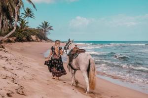 a woman walking a horse on the beach at Sea Horse Ranch in Sosúa