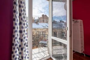 ein offenes Fenster mit Blick auf einen Balkon in der Unterkunft Cool Central Apartment in Sofia