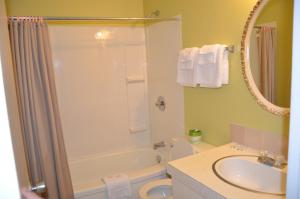 a bathroom with a tub and a toilet and a sink at Coachman Inn in Regina +51 photos
