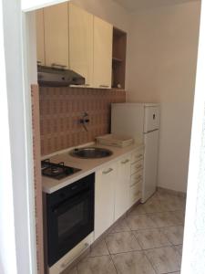 a small kitchen with a sink and a refrigerator at Apartmani Sandro in Ivan Dolac +30 photos