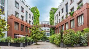 an internal courtyard of a building with plants at R&eacute;sidence Bastille Libert&eacute; in Paris