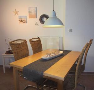 a dining room table with chairs and a light fixture at An´t Möhlen in Carolinensiel