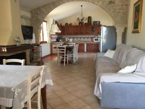 a living room with a couch and a table and a kitchen at Villa Lory in Gonnesa