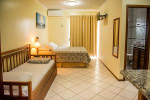 Habitación de hotel con 2 camas y baño en HANNA San Diego Apart Hotel - Canasvieiras, en Florianópolis