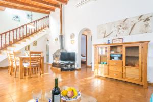 sala de estar con cocina y mesa con una botella de vino en Sa Tanqueta De Ses Roques, en Santanyí