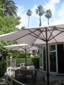 a white umbrella over a table and benches at Hotel Esperia in Genoa