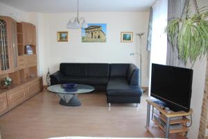 uma sala de estar com um sofá preto e uma mesa em Ferienwohnung am Gipsberg em Merzig