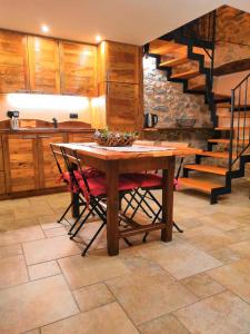 una cocina con una mesa de madera y una escalera en Souvenir De Tsaneli, en Roisan