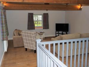 ein Wohnzimmer mit einem Sofa und einem TV in der Unterkunft Nellies Shed, Wolds Way Holiday Cottages, 3 bed spacious cottage in Cottingham