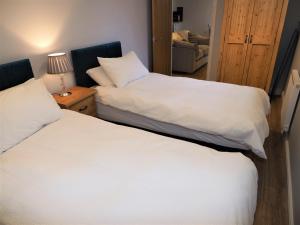 two beds sitting next to each other in a bedroom at Nellies Shed, Wolds Way Holiday Cottages, 3 bed spacious cottage in Cottingham