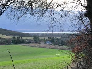a view of a green field with the ocean in the background at Nellies Shed, Wolds Way Holiday Cottages, 3 bed spacious cottage in Cottingham