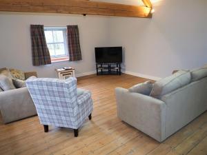 a living room with two couches and a television at Nellies Shed, Wolds Way Holiday Cottages, 3 bed spacious cottage in Cottingham
