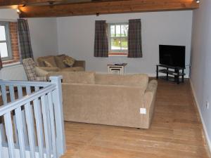 a living room with a couch and a tv at Nellies Shed, Wolds Way Holiday Cottages, 3 bed spacious cottage in Cottingham