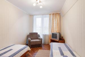 a room with two beds and a chair and a television at Druzhba hotel and restaurant in Kharkiv