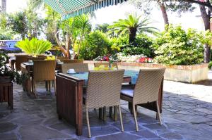 a patio with a table and chairs and palm trees at Hotel Esperia in Genoa