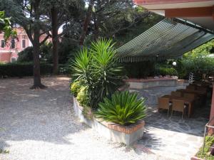 a patio with tables and chairs and plants at Hotel Esperia in Genoa