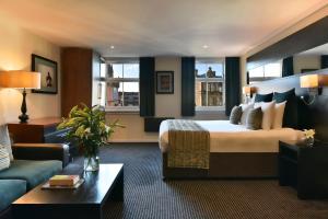
a living room filled with furniture and a large window at Fraser Suites Glasgow in Glasgow
