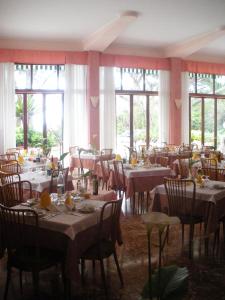 a dining room with tables and chairs and windows at Hotel Esperia in Genoa
