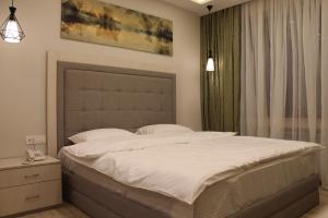 Un dormitorio con una gran cama blanca y una ventana en 4Room Hotel en Ereván