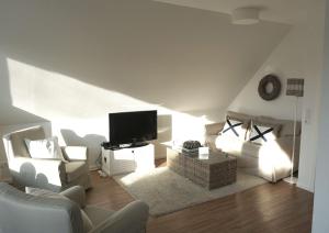 ein Wohnzimmer mit einem Sofa und einem Flachbild-TV in der Unterkunft Ferienwohnung Koje 44 in Timmendorfer Strand