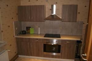 a kitchen with wooden cabinets and a stove at Ferienwohnung Wendehake in Quedlinburg