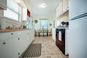 uma cozinha com armários brancos e um forno em Greenwood Beach Cottage em Elk
