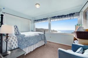 a bedroom with a bed and a large window at Greenwood Beach Cottage in Elk