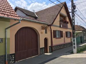 une maison avec une porte de garage marron dans une rue dans l'établissement PENSIUNEA ILEANA "Adults Only", à Orlat