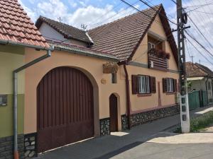 a house with a brown garage door on a street at PENSIUNEA ILEANA "Adults Only" in Orlat