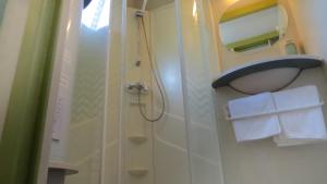 a bathroom with a shower and a sink and towels at Bungalows Bahia de la Plata in Zahara de los Atunes +17 photos