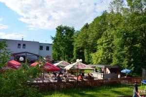 grupa ludzi siedzących w parku z parasolami w obiekcie Restaurace a penzion Zděná Bouda w mieście Hradec Králové