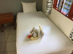 a bed with a stuffed animal and flowers on it at La Perlita in Jacó