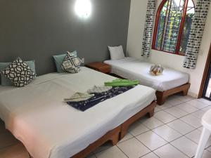 a room with two beds in a room at La Perlita in Jacó