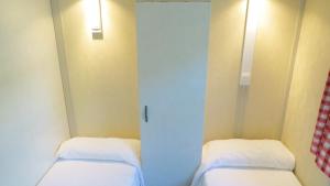 a small room with two beds and a door at Bungalows Bahia de la Plata in Zahara de los Atunes