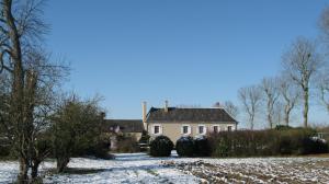 a house with two large tires in the snow at Le Petit Bois in Château-la-Vallière