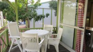a white table and chairs on a porch at Bungalows Bahia de la Plata in Zahara de los Atunes