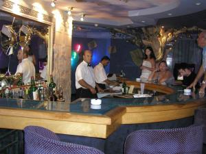 a group of people standing around a bar in a restaurant at Hotel Dreams Beach in Hammam Sousse
