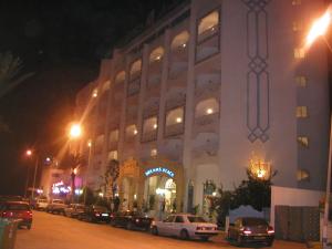 un edificio con coches aparcados delante de él por la noche en Hotel Dreams Beach en Hammam Sousse