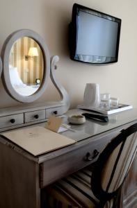 a mirror on top of a dresser with a desk at Hotel Azimut in Sveti Stefan