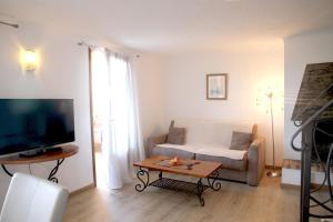 uma sala de estar com um sofá e uma mesa em Résidence A Licetta em Porto-Vecchio